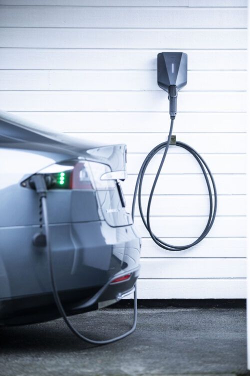 Easee Charge Lite 11 kW lader – med kWh måler, WiFi og 4G SIM kort – fjernaflæsning – Sort lader grå bil i hjemmet
